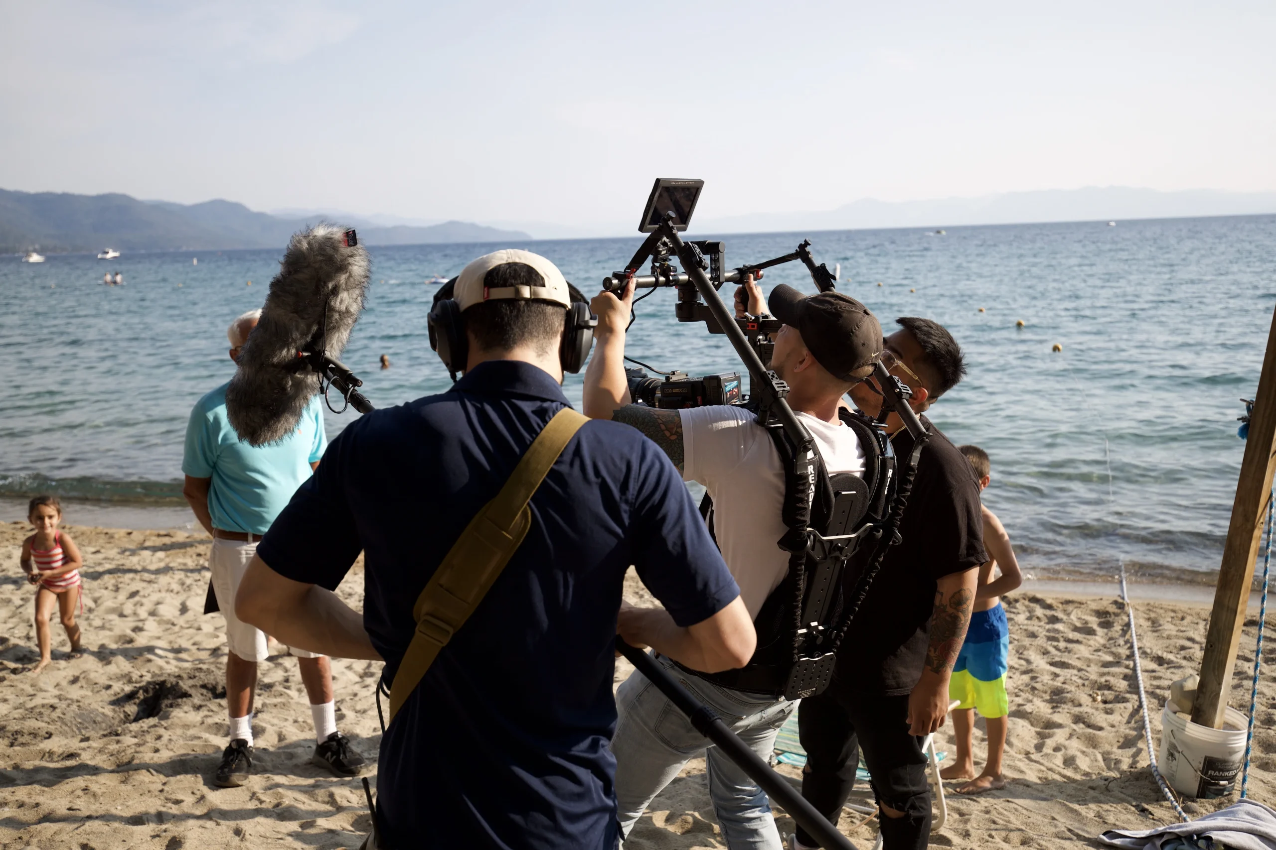 A boy watching quietly from the sand during a lakeside interview shoot